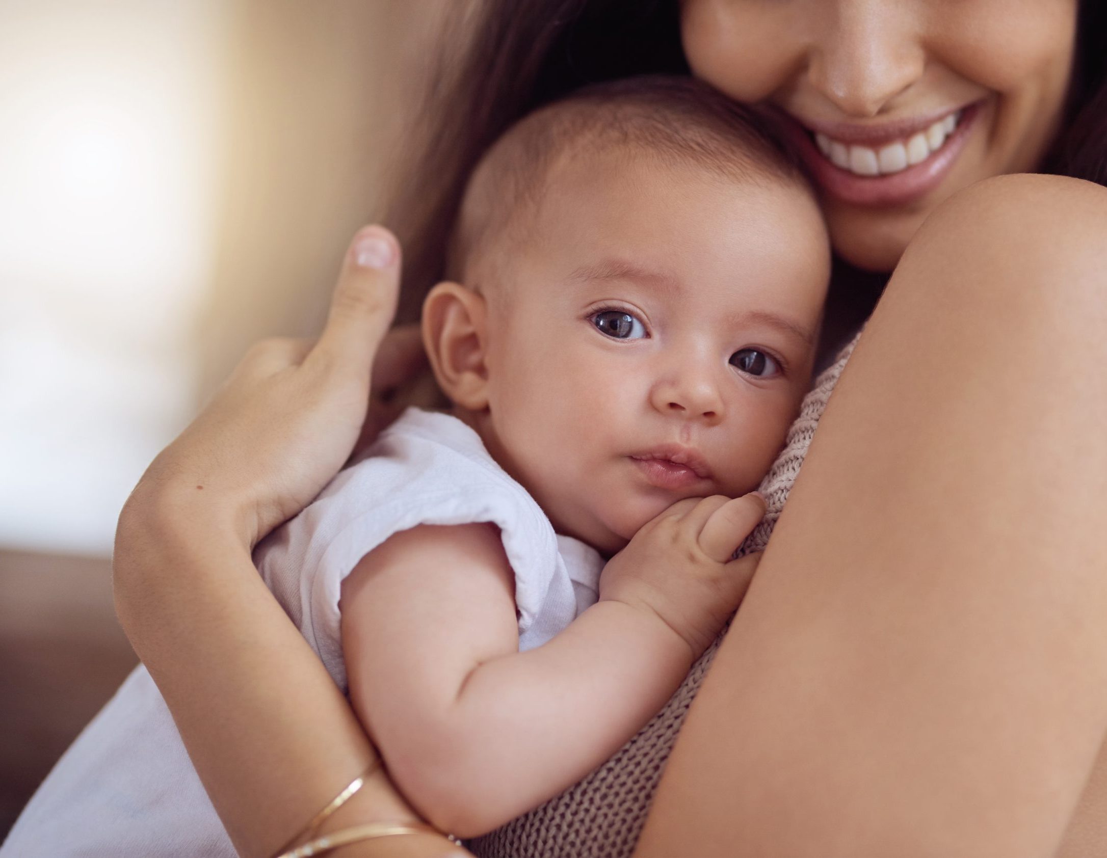 smiling mother holding her baby close